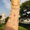Detailed shot of golden arm jewelry with crystal chips and butterfly teardrop pendants - White Crystal