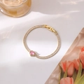 Gedetailleerd macro-zicht op de vergulde armband met roze hartsteen en zirkoonstenen - Goud Hart Stijl