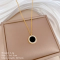 Close-up of a gold necklace with round black agate pendant and sparkling zircon stones - Choker Necklace / Gold