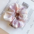 Tie-dye fabric hair scrunchie in purple and orange tones on minimalist magazine background - Phantom Purple