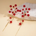 Dettaglio di orecchini a fiore dorati con perline rosse e lunghe nappe pendenti - Ago d'Argento Rosso (HE29304) / Rosso