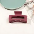 Matte deep plum rectangular hollow hair claw clip displayed on a green decorative plate - 8.5cm Rectangular - Matte Wine Red