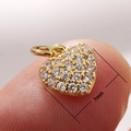 Micro shot of 7mm heart pendant in gold finish with sparkling clear stones on a fingertip - 7mm / Full Zircon Heart