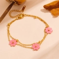 Detailed macro view of a gold double-layer daisy bracelet with three pink flower pendants - Pink Shell Bracelet (L504)