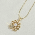 Collana dorata con ciondolo a fiore, perla grande, farfalla e dettagli in zirconi - Perla a Fiore