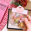 Dettaglio di elastici per capelli a fiore in colori pastello in confezione trasparente - Stile Fiore