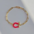 Detail of golden paperclip chain bracelet featuring a vibrant pink U-shaped horseshoe buckle - Rose Red