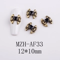 Detail of vintage gold bow nail art charm with black heart gemstone on white nail tip - AF33-Bronze Black Rhinestone Bow