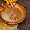 Pink oval crystal brooch with golden bow and pearl detail on vintage musical paper - Oval Bowknot-Pink