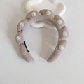 Beige padded braided headband with pearl accents on a soft cloud background - Grey With Pearls