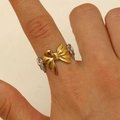 Unique mixed metal ring featuring a golden bow with silver wings on a female index finger - Two-Tone Gold Silver Bow Wings (DZ-485)