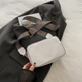 White floral embossed rectangular crossbody bag with geometric wide strap on dark jacket - White
