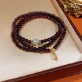 Dettaglio del bracciale di granato rosso con ciondolo Fu dorato in una scatola da regalo - Bracciale a Strati in Granato Giada Nefrite con Pendente Benedizione (Scatola Regalo Squisita)