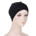 Detail of black pleated turban hat with elastic fabric texture on model head - Black