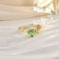Close-up of golden ring featuring a heart-shaped green gemstone with clear side stones - Green Heart Open Delicate Style (JZ0152)