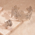 Dettaglio del set bracciale e anello a fiore in argento su base di marmo - Argento