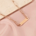 Detailed view of rose gold rectangle bar necklace on elegant silk background - Rose Gold + 1 Accessory