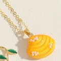 Detailansicht einer orangefarbenen Muschel-Halskette mit Emaille-Details und Goldkette - Künstliche Perle Muschel Stil