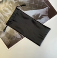 Detailansicht eines schwarzen Mikrofaser-Kordelzugbeutels für Sonnenbrillen auf einem Magazin - Schwarz
