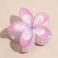 Detailed close-up of pink and white frangipani flower hair claw with a glittery finish - Gradient Pink