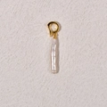 Detail shot of a refined baroque pearl pendant with a golden metal clasp on a textured surface - White Small Bar Pearl + Gold Universal Buckle