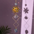 Macro detail of golden metal flower suncatcher with raw blue crystal stone and rainbow light - Blue Sodalite