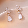 Close-up of gold drop earrings with pear-shaped cubic zirconia on champagne silk fabric - Golden Water Drop Flower Cluster Style (E0869)