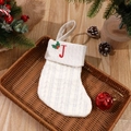 White cable knit Christmas stocking with red embroidered letter J on brown tray - Letter J