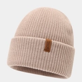 Close-up of knit texture and premium leather patch on oatmeal winter beanie hat - Khaki