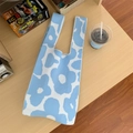 Primer plano de un bolso de punto con flores azules y blancas sobre mesa de madera rústica - Azul Cielo