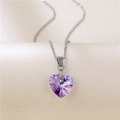 Polished silver chain with a faceted purple heart-shaped crystal pendant on a pedestal - Heart of the Ocean (Purple)