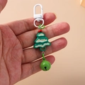 Green Christmas tree keychain with matching bell and white metal clasp on soft background - Christmas Tree