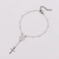 Macro shot of silver metal chain bracelet with Virgin Mary medal and cross pendant - Clear