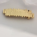 Elegant gold wavy hair clip in minimalist metal finish on premium textured backdrop - Gold Wave Irregular Barrette