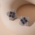Detail view of geometric square stud earrings with purple zircons on a beige stone base - Purple Zirconia Geometric Stud Earrings with Silver Pin