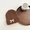 Nahaufnahme der braunen Strickmütze mit dicker Textur und weißer Schleifenstickerei - 3-8 Jahre / Kaffeebraun
