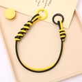 Detail of yellow and black braided PU leather phone strap with circular ring clasps - Yellow + Black