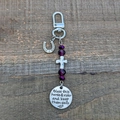 Vintage Saddle and Bridle Charm Keychain with purple beads on a rustic wood background - Amethyst and Horseshoe