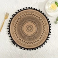 Detail of round jute placemat featuring black geometric patterns and fringe tassels - Black Pom-poms Pattern 1