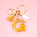 Detail of Letter G resin keychain with gold leaf, yellow stones and colorful tassels - Letter G