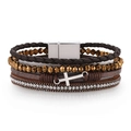 Detail showing multilayer braided leather bracelet with cross charms and magnetic clasp - Brown