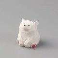 Macro shot of hand-carved white wooden polar bear with minimalist facets and pink paw prints - White Wood Carved Bear