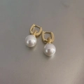 Detalle de pendientes colgantes bañados en oro con perlas blancas redondas y elegantes - Hebilla de Oreja de Perla y Circonita Dorada