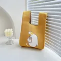 Bright yellow knitted handbag with cute white duck pattern and minimalist wrist strap - Yellow Crooked Head Duck