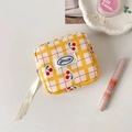 Gelbe karierte Kirsch-Tasche mit Make-up und Lifestyle-Accessoires flach hingelegt - Gelb