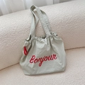 Dettaglio della borsa in tela verde salvia con stampa Bonjour rossa e coulisse - Grigio chiaro
