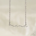 Gros plan du pendentif Mama en argent poli sur une chaîne fine et tissu beige doux - Couleur Acier (KN282195-KLX)
