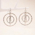 Detailed view of layered silver geometric circular earrings on a white display stand - Silver
