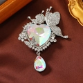 Elegant silver butterfly brooch with heart and teardrop crystals on dark fabric - White
