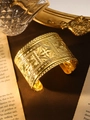 Nahaufnahme des goldenen Bohemian-Manschettenarmbands mit floralen und geometrischen Mustern - Raute Blumen Gold